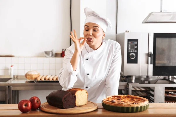 Imagen de una chef caucásica vestida de uniforme blanco, posando en k —  Fotos de Stock