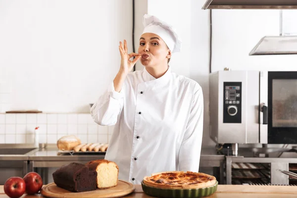 Image d'une cuisinière européenne portant un uniforme blanc, posant en ki — Photo