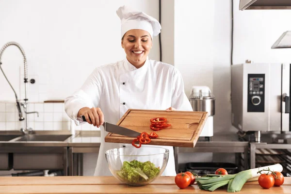 Foto di chef donna europea che indossa uniforme bianca facendo insalata — Foto Stock
