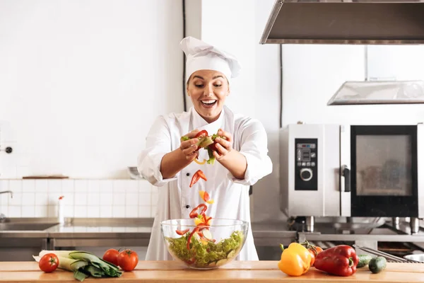 Photo of beautiful woman chef wearing white uniform making salad — Stock Photo, Image