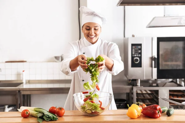 Photo de femme chef heureuse portant un uniforme blanc faisant de la salade w — Photo