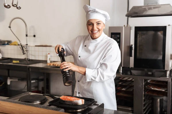 Smiling woman chef cook wearing uniform cooking