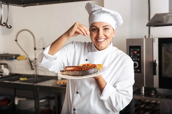 Imagen de mujer alegre chef vistiendo uniforme blanco, sosteniendo la placa —  Fotos de Stock