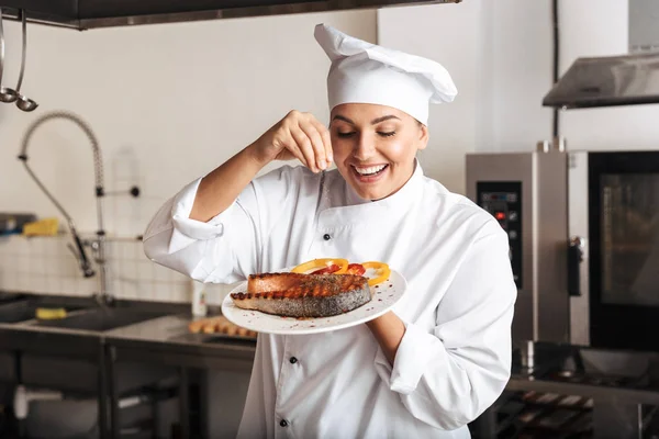 Image d'une femme chef excitée portant un uniforme blanc, tenant la plaque — Photo