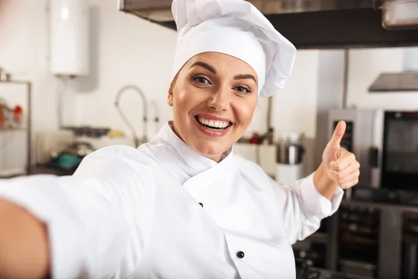 Portrait of professional woman chef wearing white uniform, takin