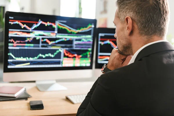 Bild eines selbstbewussten Geschäftsmannes, der im Büro arbeitet und zusieht — Stockfoto