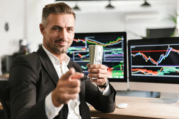 Image of handsome businessman holding pack of money while workin — Stock Photo, Image