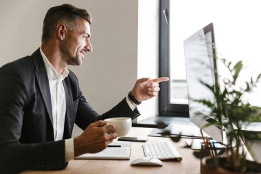 Görüntü üzerinde çalışırken kahve içme güzel iş adamı 