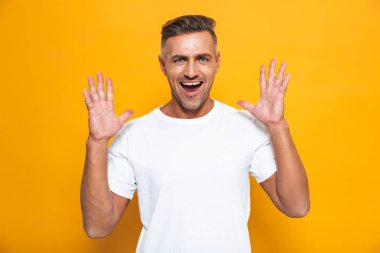Yakışıklı mutlu heyecanlı adam sarı duvar arka plan üzerinde izole poz.