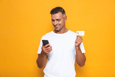 Görüntü güzel adamın 30'lu yaşlarda beyaz t-shirt holding cep telefonu