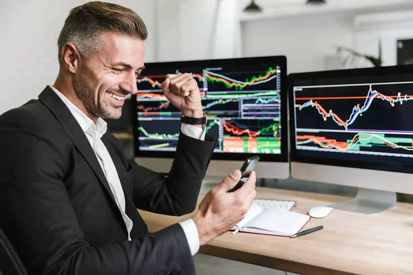 Retrato del gerente masculino usando el teléfono móvil mientras trabaja con d — Foto de Stock