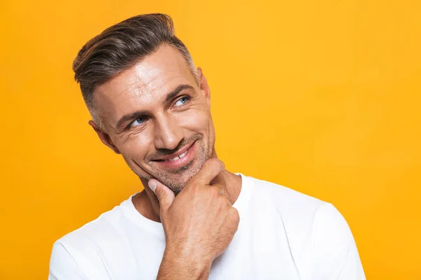 Schöner glücklicher aufgeregter Mann posiert isoliert über gelbem Wandhintergrund. — Stockfoto