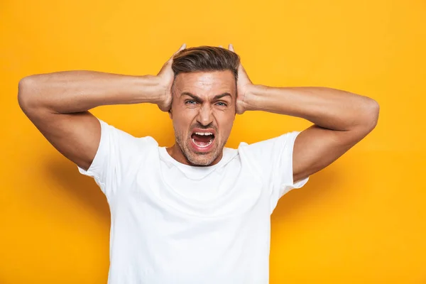 Image of angry guy 30s in white t-shirt screaming and grabbing h — Stock Photo, Image