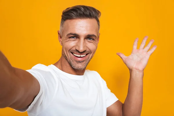 Imagem do homem otimista dos anos 30 em t-shirt branca sorrindo e tomando — Fotografia de Stock