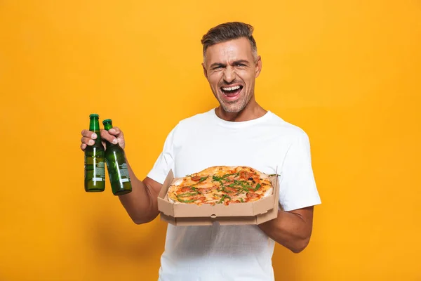 Imagen del hombre alegre de 30 años en camiseta blanca bebiendo cerveza y comiendo — Foto de Stock