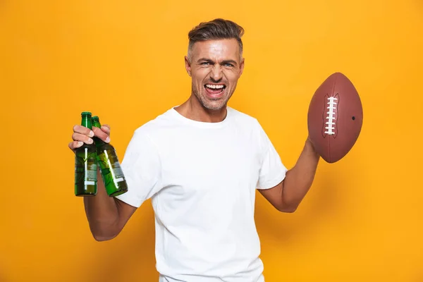 Imagen del alegre hombre de 30 años en camiseta blanca bebiendo cerveza y holdi — Foto de Stock