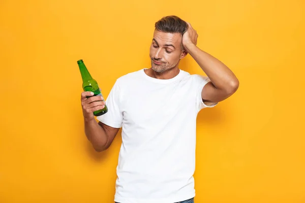 Imagen del hombre borracho de 30 años en camiseta blanca sosteniendo botella y bebida — Foto de Stock