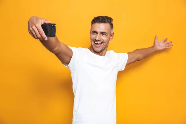 Imagem de homem bonito 30 anos em branco t-shirt rindo e taki — Fotografia de Stock