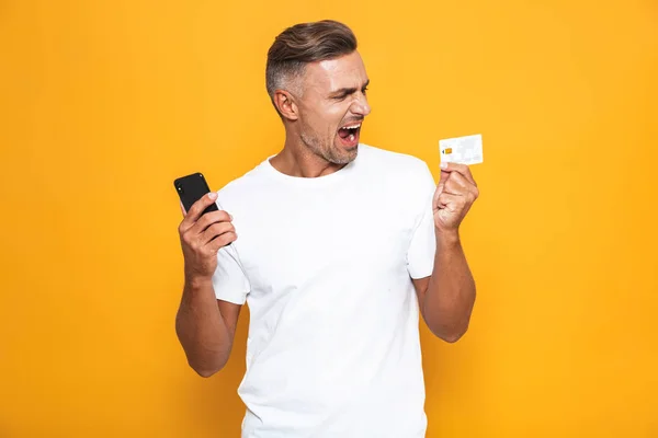 Imagen de tipo caucásico 30s en camiseta blanca sosteniendo teléfono móvil — Foto de Stock