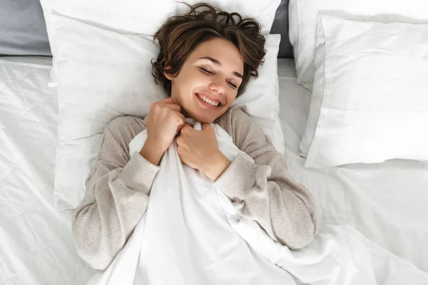 Glimlachend jong meisje ontspannen in bed — Stockfoto