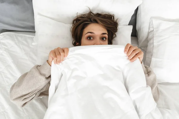 Usmívající se mladá dívka relaxační v posteli — Stock fotografie