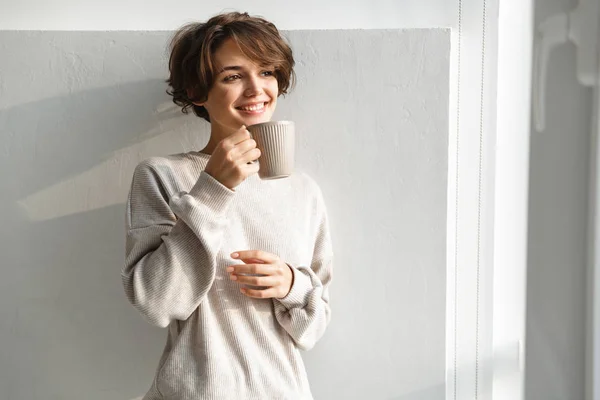 Jovencita sonriente tomando una taza de té — Foto de Stock