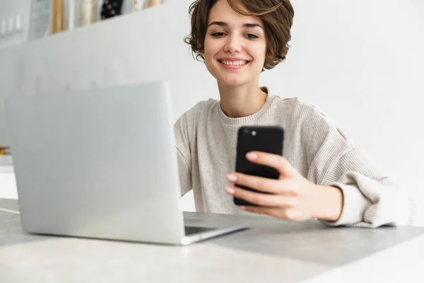 Sorrindo jovem mulher trabalhando no computador portátil — Fotografia de Stock