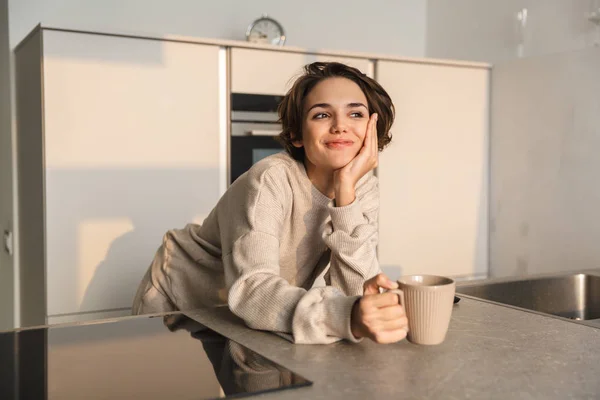 Sorridente giovane donna che beve una tazza di tè — Foto Stock