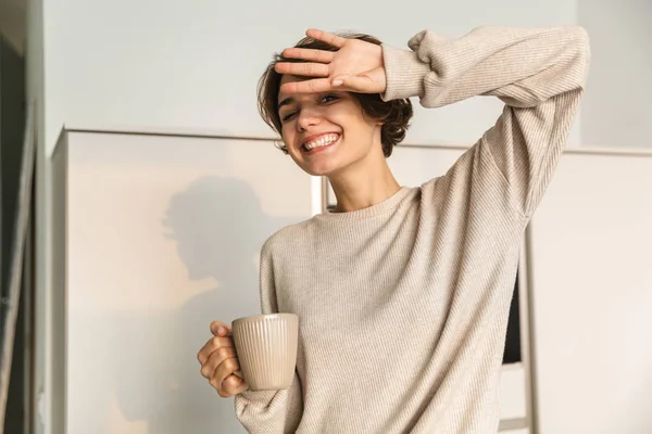Smiling young woman having cup of tea — Stock Photo, Image
