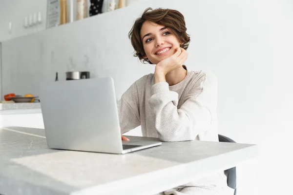 Sonriente joven mujer que trabaja en el ordenador portátil — Foto de Stock