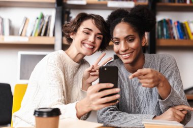 İki neşeli genç kız öğrencileri okuyor