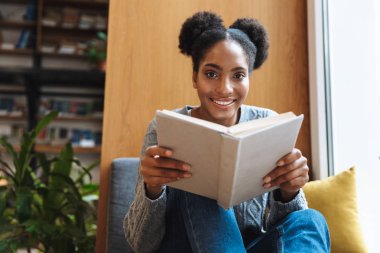 Kütüphanede okuyan mutlu genç öğrenci kız