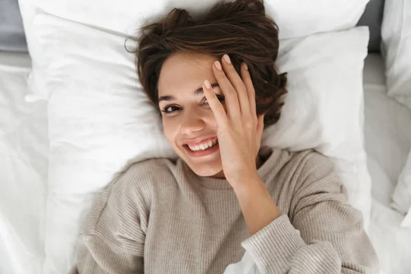 Sonriente chica joven relajarse en la cama —  Fotos de Stock