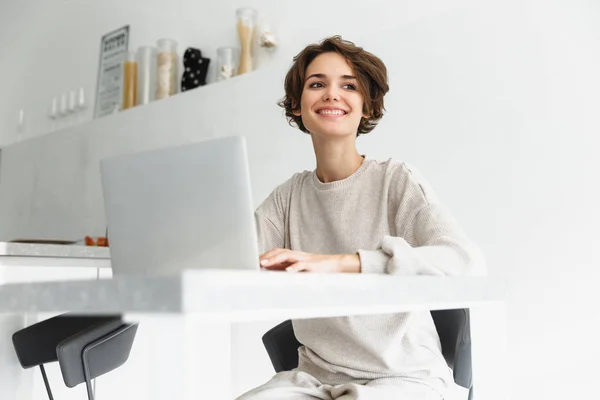 Sorrindo jovem mulher trabalhando no computador portátil — Fotografia de Stock