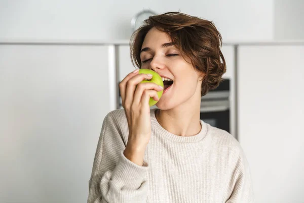Uśmiechnięta młoda kobieta trzymająca zielone jabłko — Zdjęcie stockowe