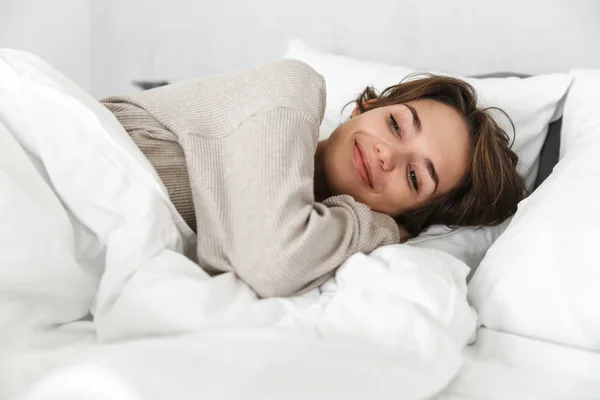 Glimlachend jong meisje ontspannen in bed — Stockfoto