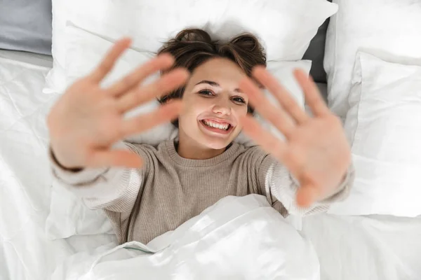 Glimlachend jong meisje ontspannen in bed — Stockfoto