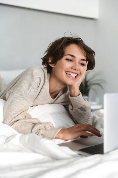 Usmívající se mladá dívka relaxační v posteli — Stock fotografie