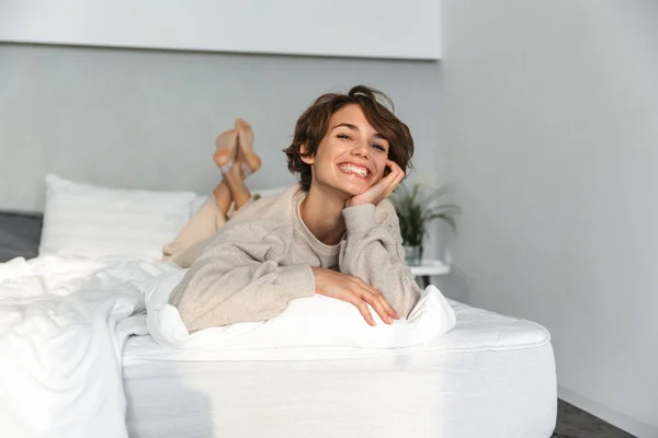 Sonriente chica joven relajarse en la cama — Foto de Stock