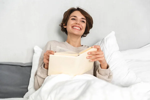 Sonriente chica joven relajarse en la cama por la mañana —  Fotos de Stock