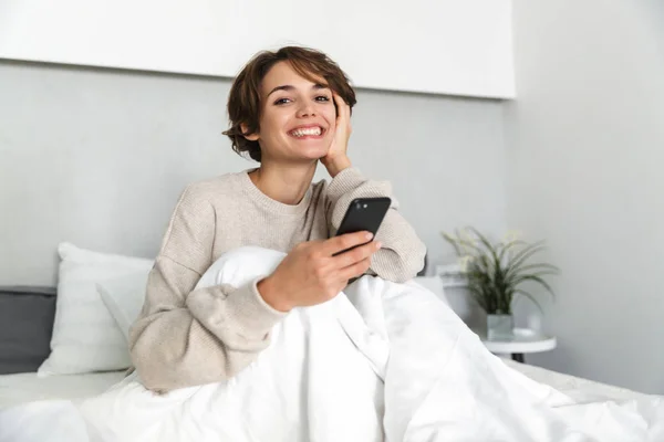 Lächelndes junges Mädchen entspannt sich im Bett — Stockfoto