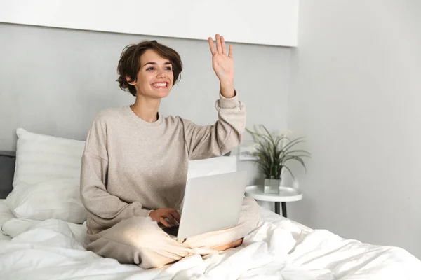 Lächelndes junges Mädchen entspannt sich im Bett — Stockfoto