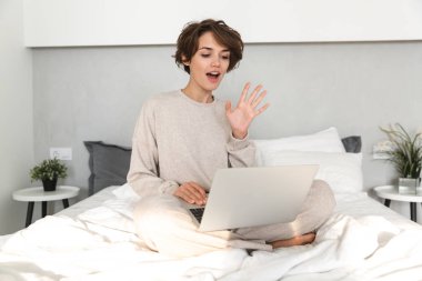 Gülümseyen genç kız yatakta rahatlatıcı