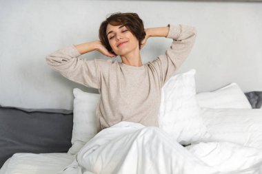 Sabah yatakta rahatlatıcı gülümseyen genç kız