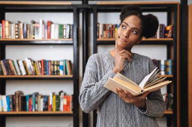 Kütüphanede okuyan mutlu genç öğrenci kız