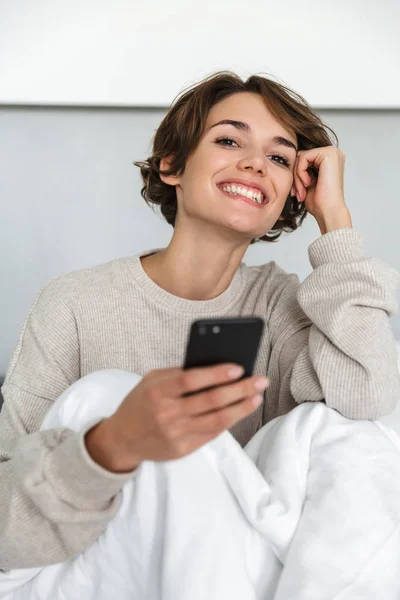 Sonriente chica joven relajarse en la cama — Foto de Stock