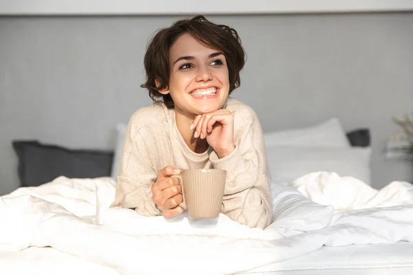 Glimlachend jong meisje ontspannen in bed — Stockfoto