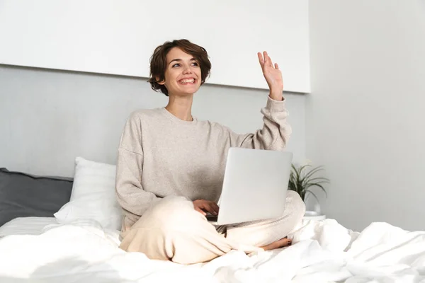 Lächelndes junges Mädchen entspannt sich im Bett — Stockfoto