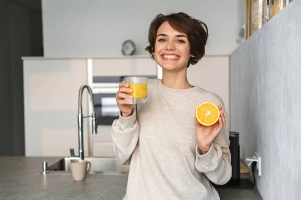 Sonriente joven sosteniendo naranja — Foto de Stock