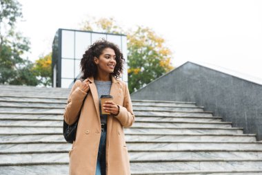 Yürüyüş ceket giyen neşeli genç Afrika kadın